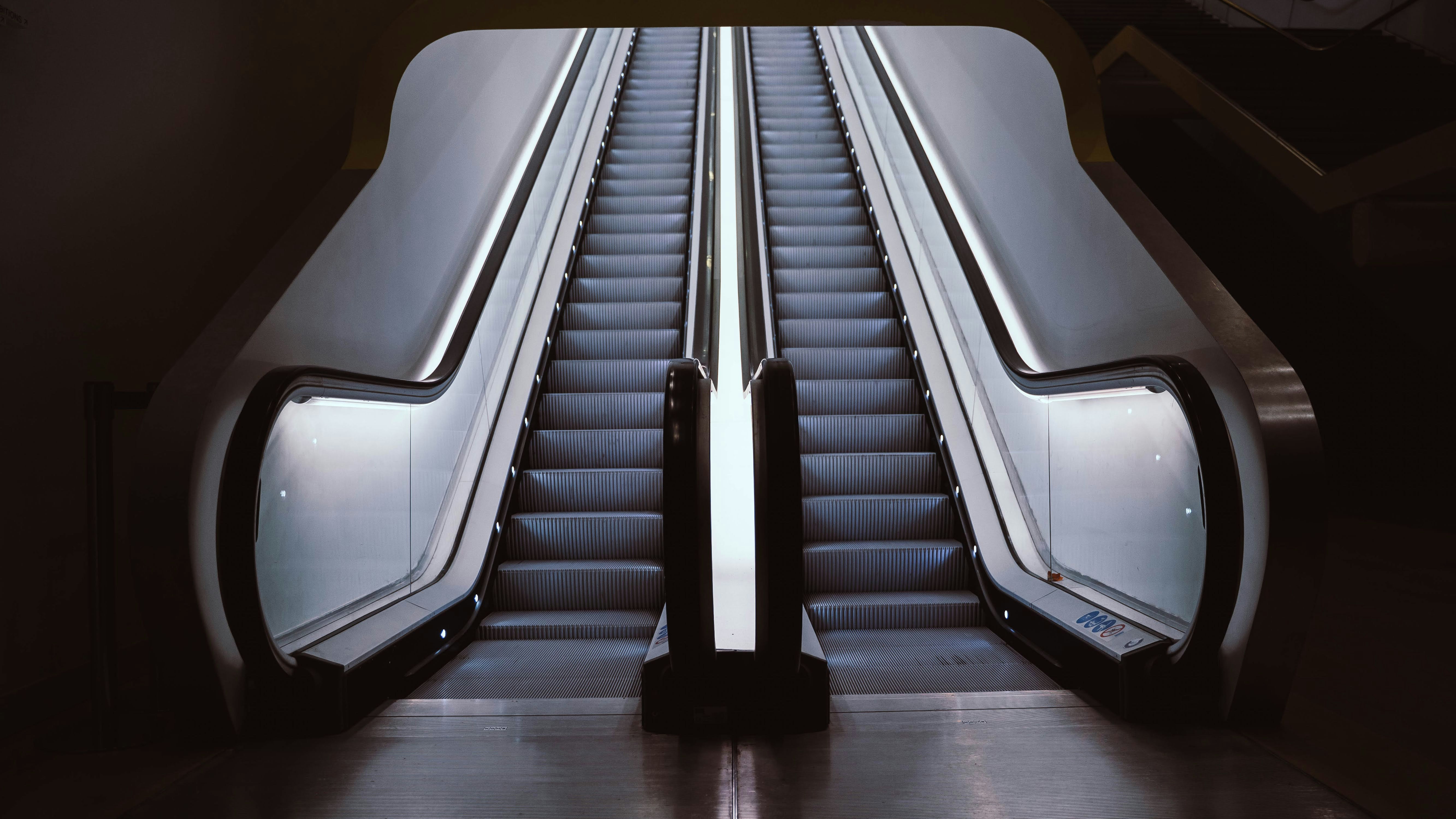 an escalator in a train station with a metal railing