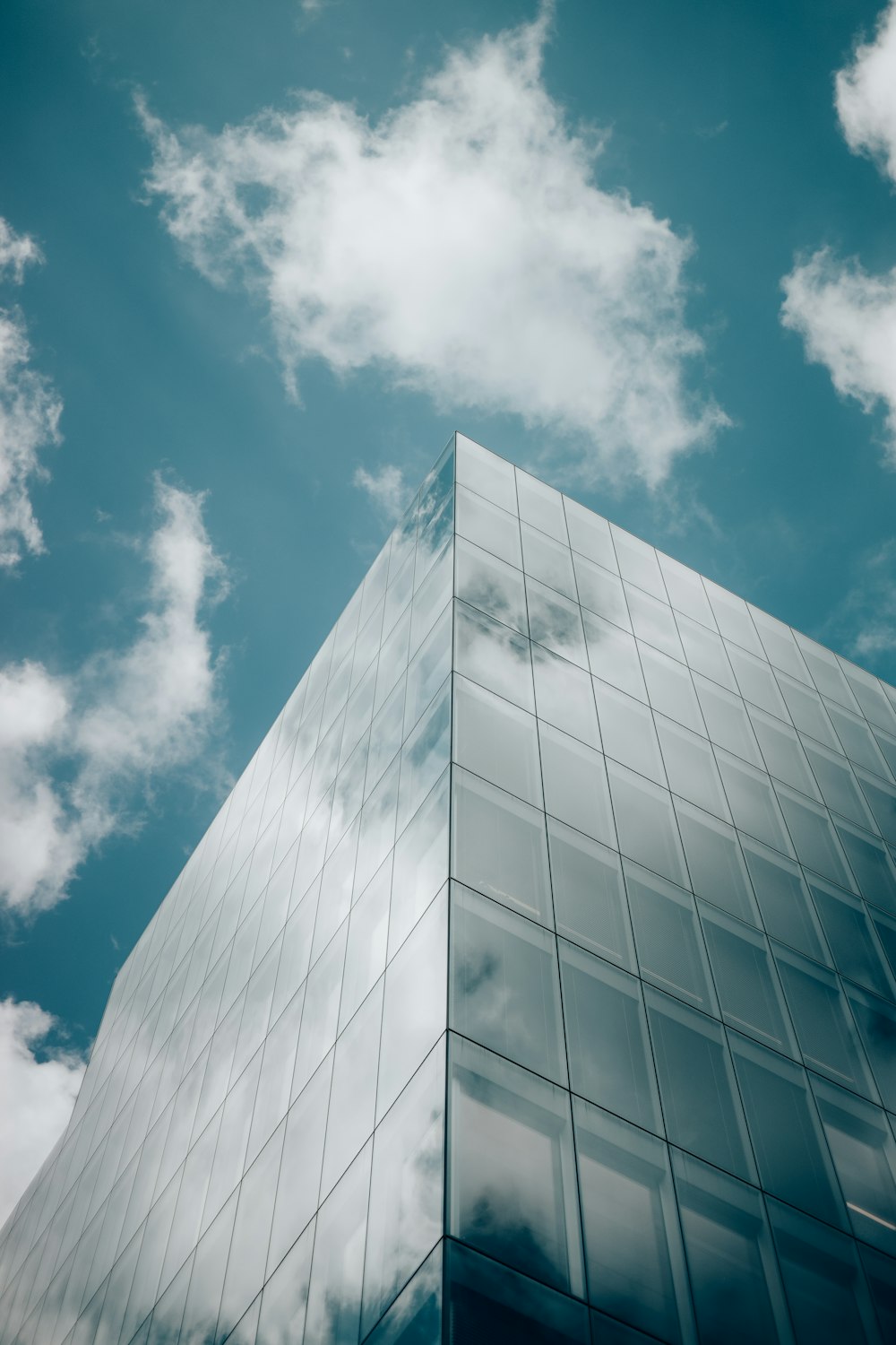 a tall glass building with a sky background