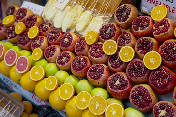 A vibrant display of fresh coconuts, pomegranates, and onions stacked neatly at Al Aweer Market in Dubai.