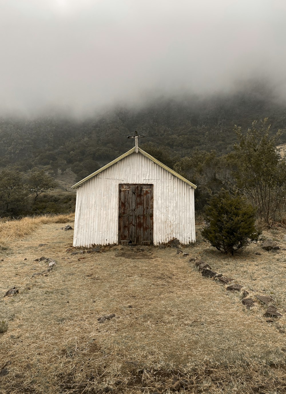 a small white building with a cross on top of it