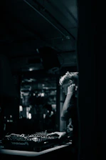 Close-up of a DJ mixing tracks with a focused expression in a lively club setting.