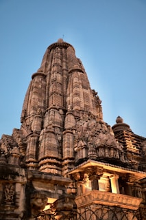 An ancient temple carved into rock with intricate stone sculptures bathed in golden light.