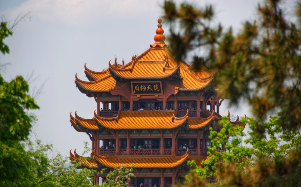 a tall building with a yellow roof surrounded by trees