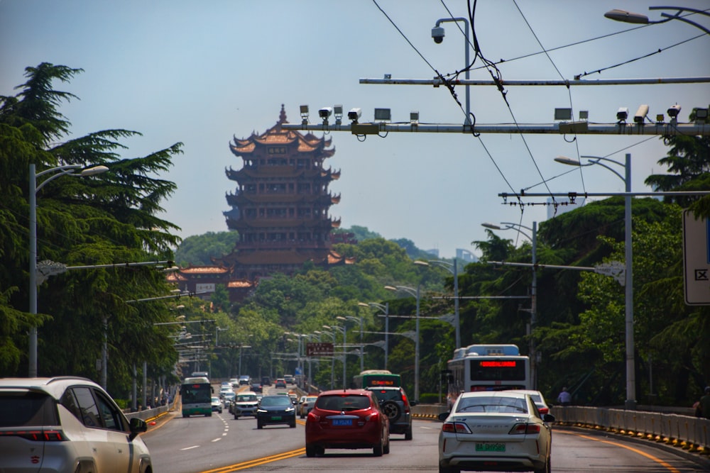 cars driving down a road with a tall tower in the background