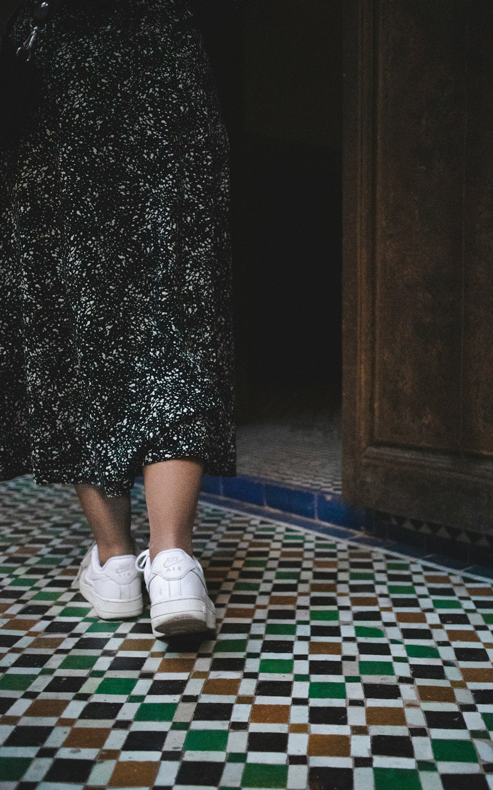 a close up of a person walking on a tiled floor