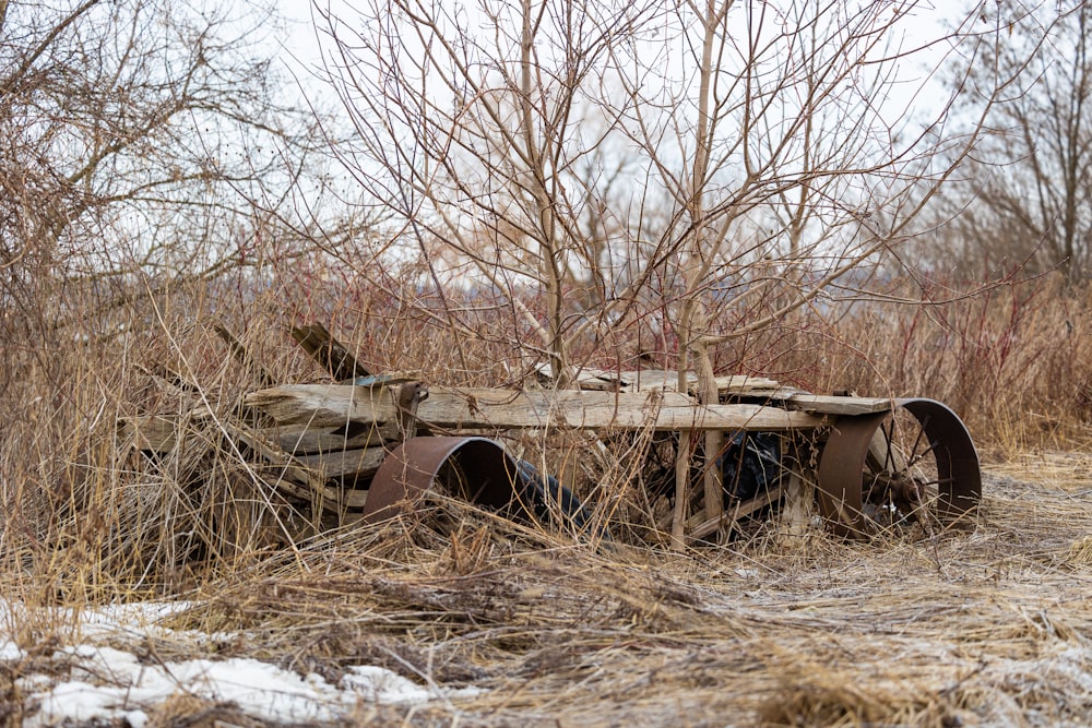 a rusted out car sitting in the middle of a field