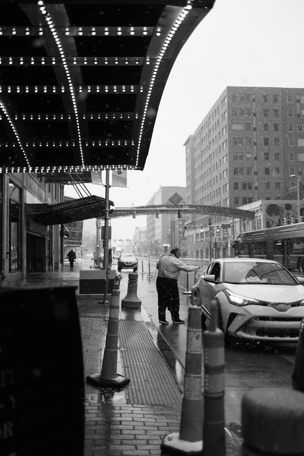 a black and white photo of a man walking down the street