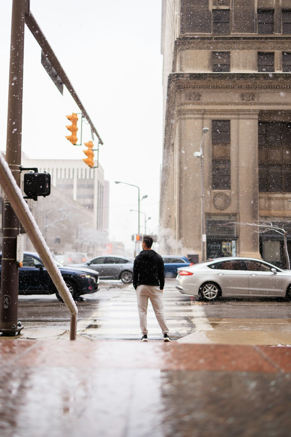 a man standing on a street corner in the rain