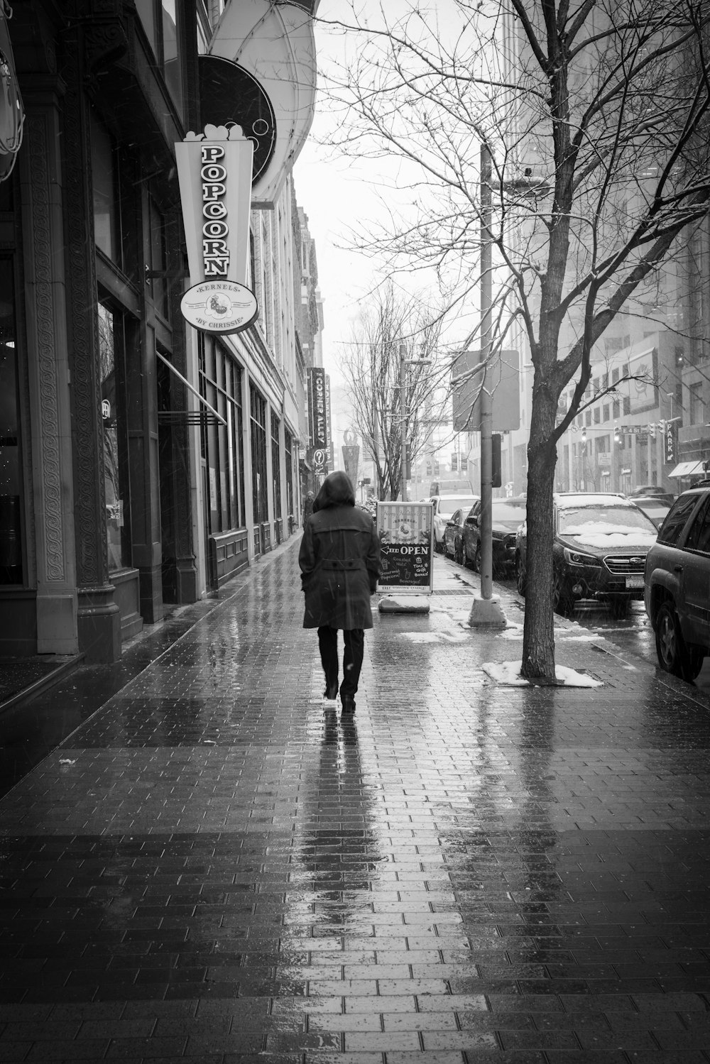 a person walking down a sidewalk in the rain