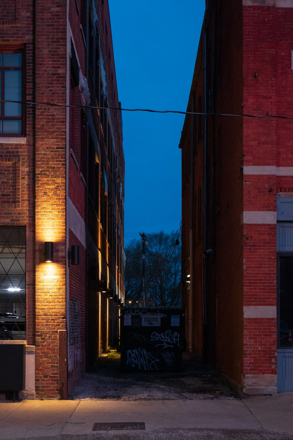 a dark alley way with graffiti on the side of buildings