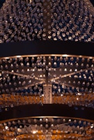 A large, ornate chandelier with numerous crystal pendants hanging in intricate patterns. The lighting creates a warm glow, enhancing the elegance and adding a sense of luxury.