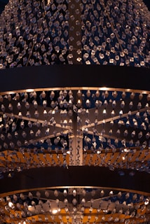 A large, ornate chandelier with numerous crystal pendants hanging in intricate patterns. The lighting creates a warm glow, enhancing the elegance and adding a sense of luxury.