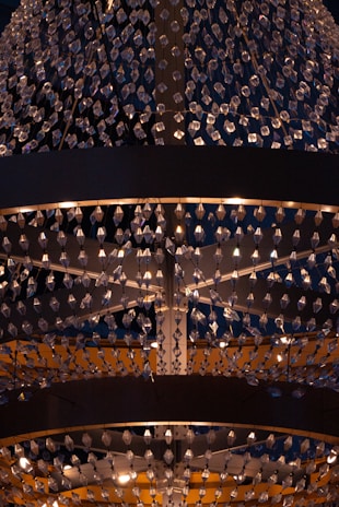 A large, ornate chandelier with numerous crystal pendants hanging in intricate patterns. The lighting creates a warm glow, enhancing the elegance and adding a sense of luxury.