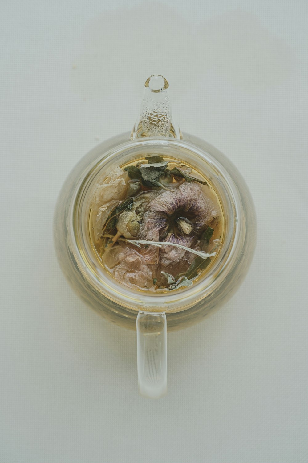 a glass jar filled with dried flowers on top of a table