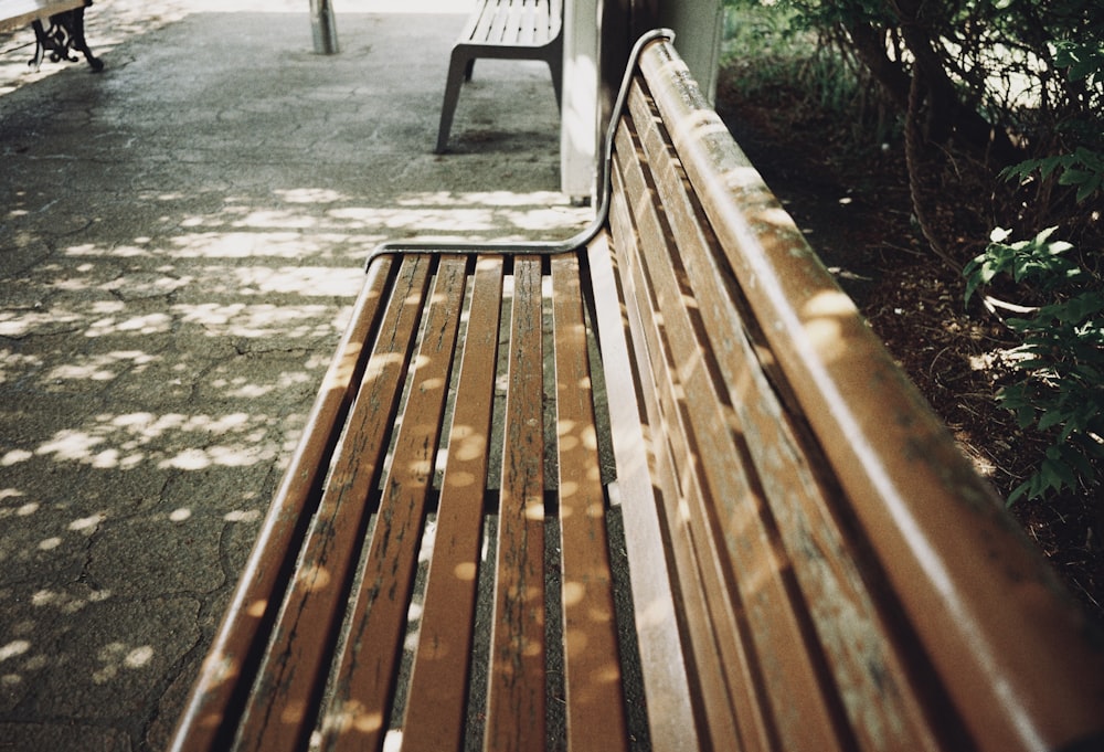 a wooden bench sitting on top of a sidewalk