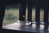 Soft focus image of a white flower wreath resting on a peaceful garden bench.