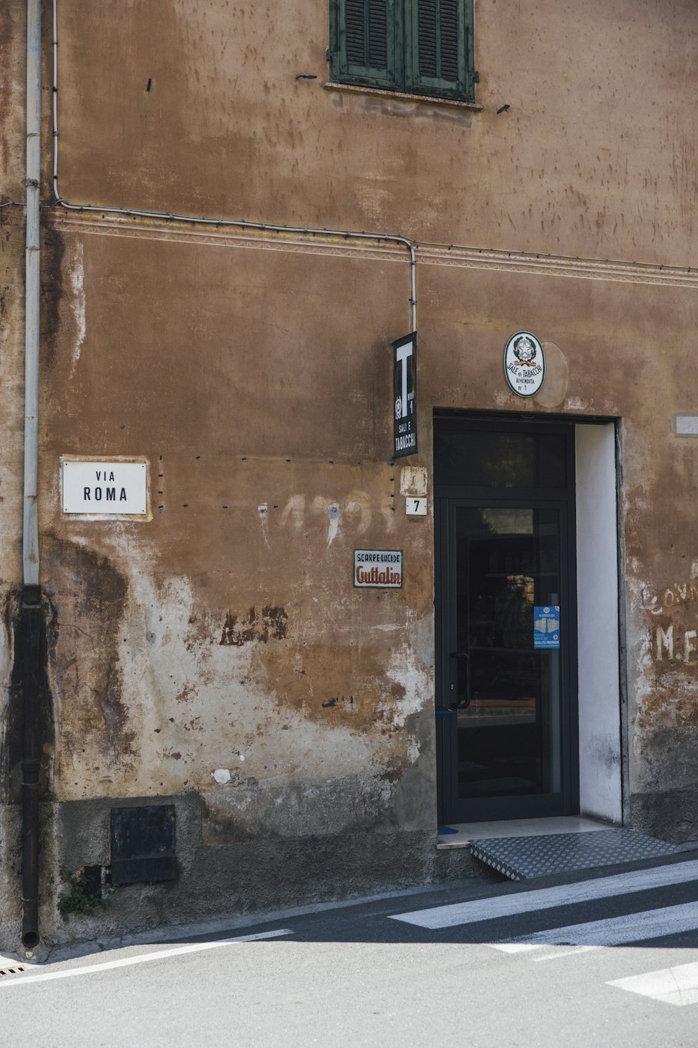 a brown building with a black door and window