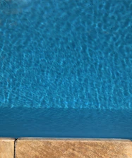 A serene swimming pool with gentle ripples reflecting soft blue and sandy tones.