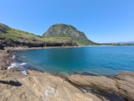 A serene view of Jeju Island's coastal cliffs under a clear blue sky.