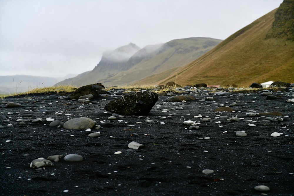 rocks and gravel on the ground with a mountain in the background