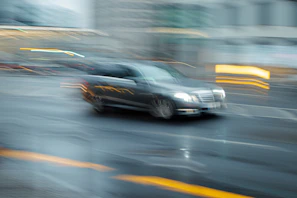 A high-speed police chase weaving through narrow European city streets at dusk.