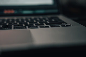 Close-up of a refurbished laptop keyboard shining under soft lighting in a stylish retail space.