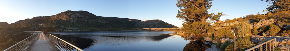 a bridge over a lake with mountains in the background