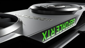 Close-up of a graphics card featuring two large cooling fans and the text 'GEFORCE RTX' displayed in green. The metallic surface has a sleek, modern design with embossed characters 'RTX 2080 Ti'.