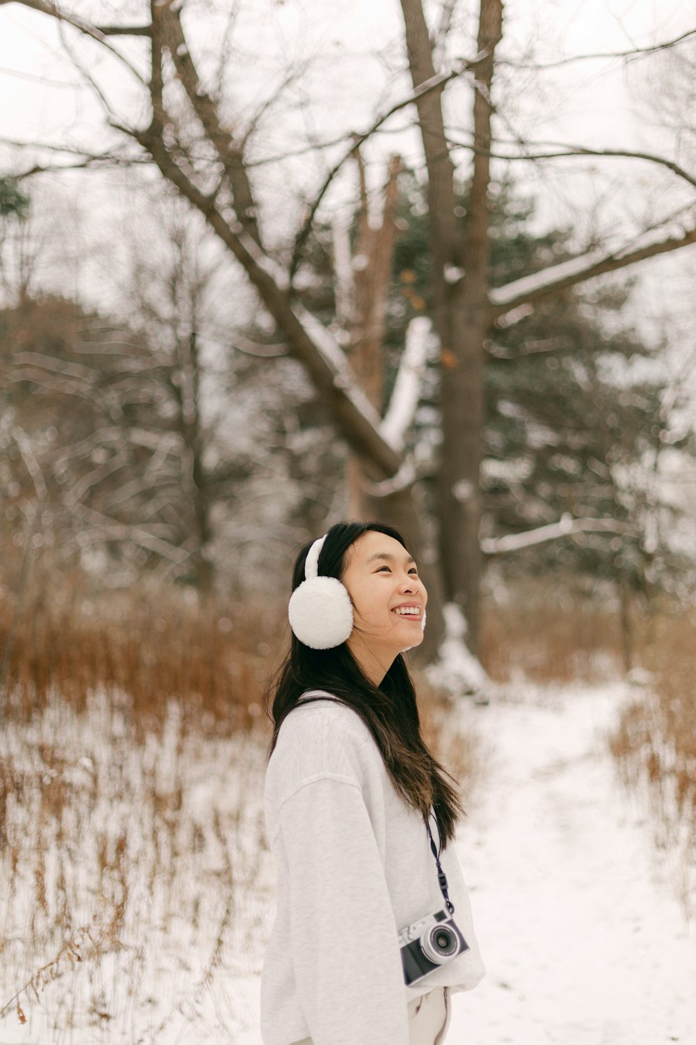 a woman standing in the snow wearing headphones