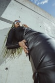 a woman laying on a black leather couch
