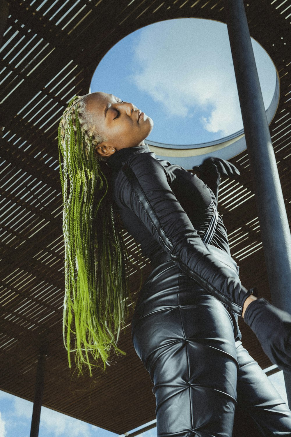 a woman with green hair and black leather outfit