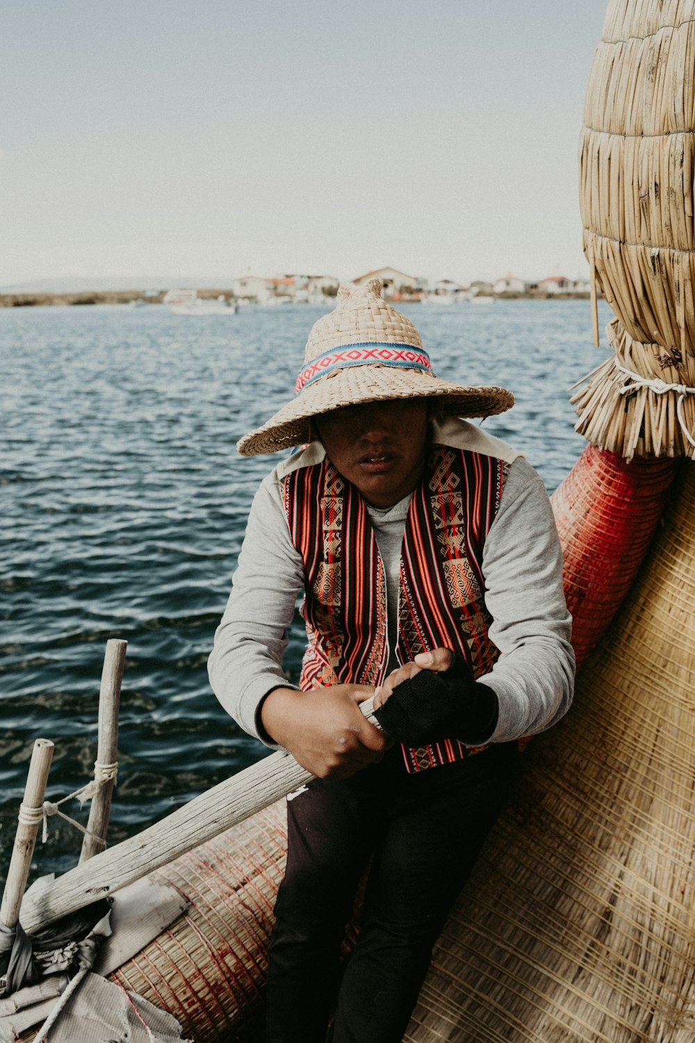 a man in a straw hat sitting on a boat