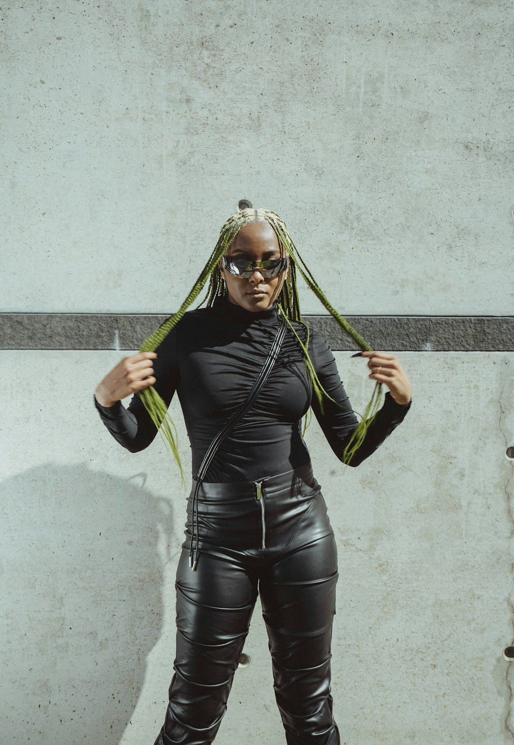 a woman with dreadlocks standing in front of a wall