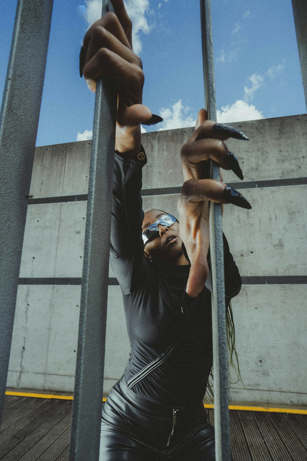 a woman holding onto a metal pole with her hands