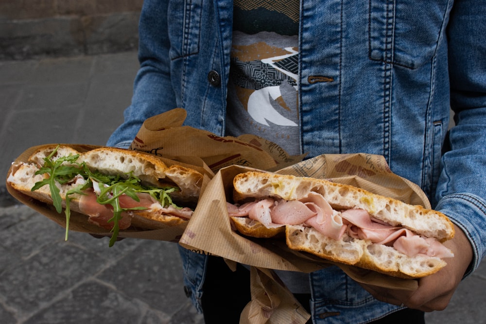 a person holding a sandwich in their hands