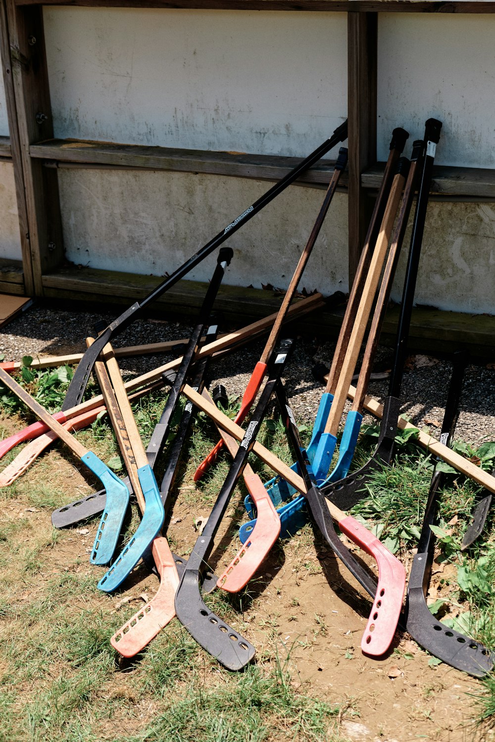 a pile of shovels sitting on top of a grass covered field