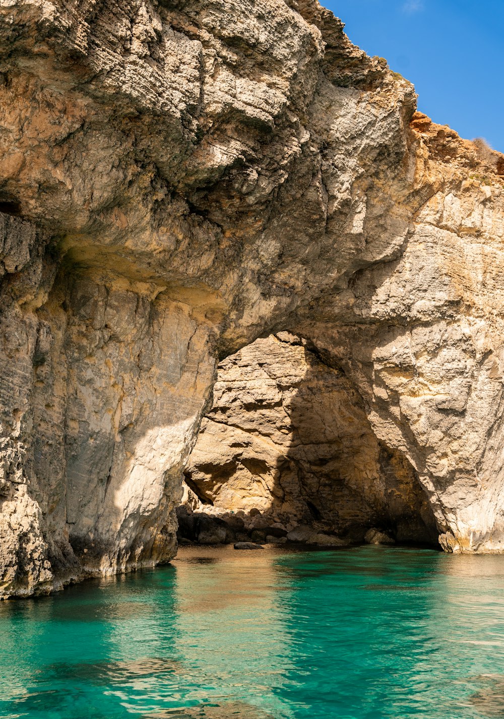 a large rock formation with a blue body of water in front of it