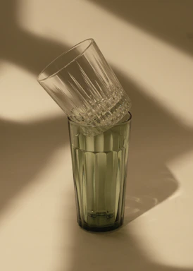 Close-up of sturdy, clear Duralex glass tumblers stacked neatly on a kitchen counter with soft morning light.
