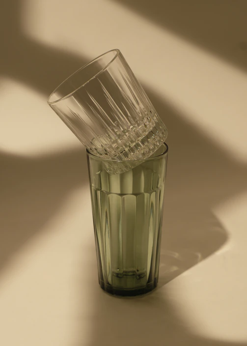 Close-up of sturdy, clear Duralex glass tumblers stacked neatly on a kitchen counter with soft morning light.