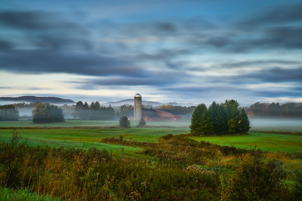 a foggy field with a light house in the distance