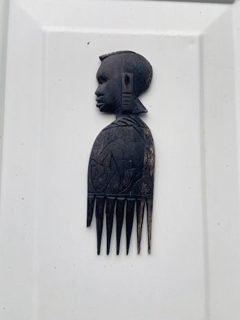 Hands holding a wooden comb, highlighting the smooth finish and natural grain.