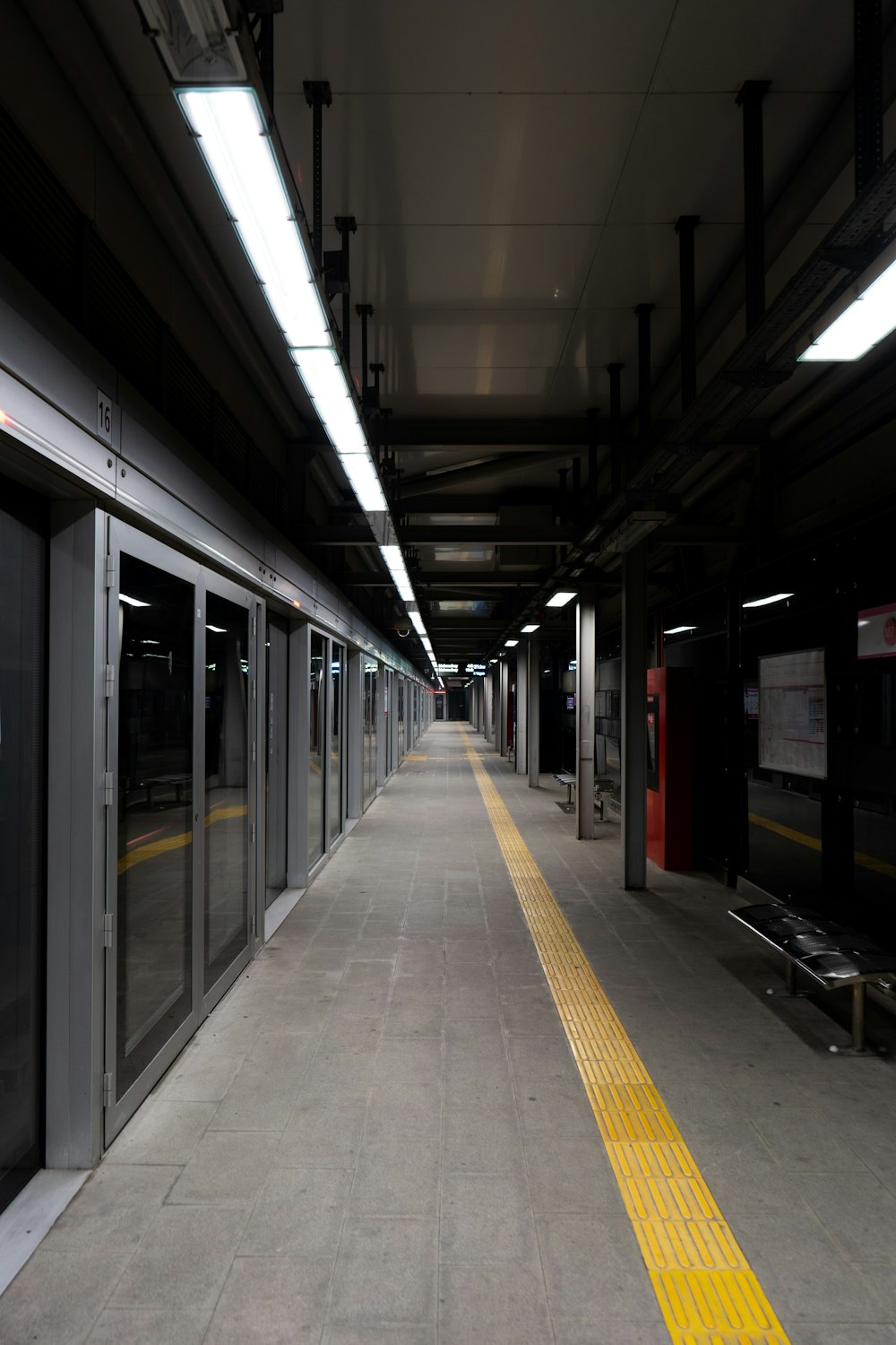 a train station with a yellow line on the floor