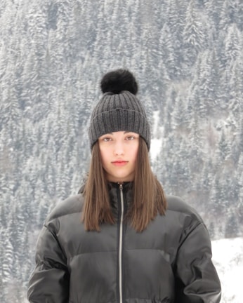 Model wearing a winter jersey outdoors with snow-covered trees in the background.