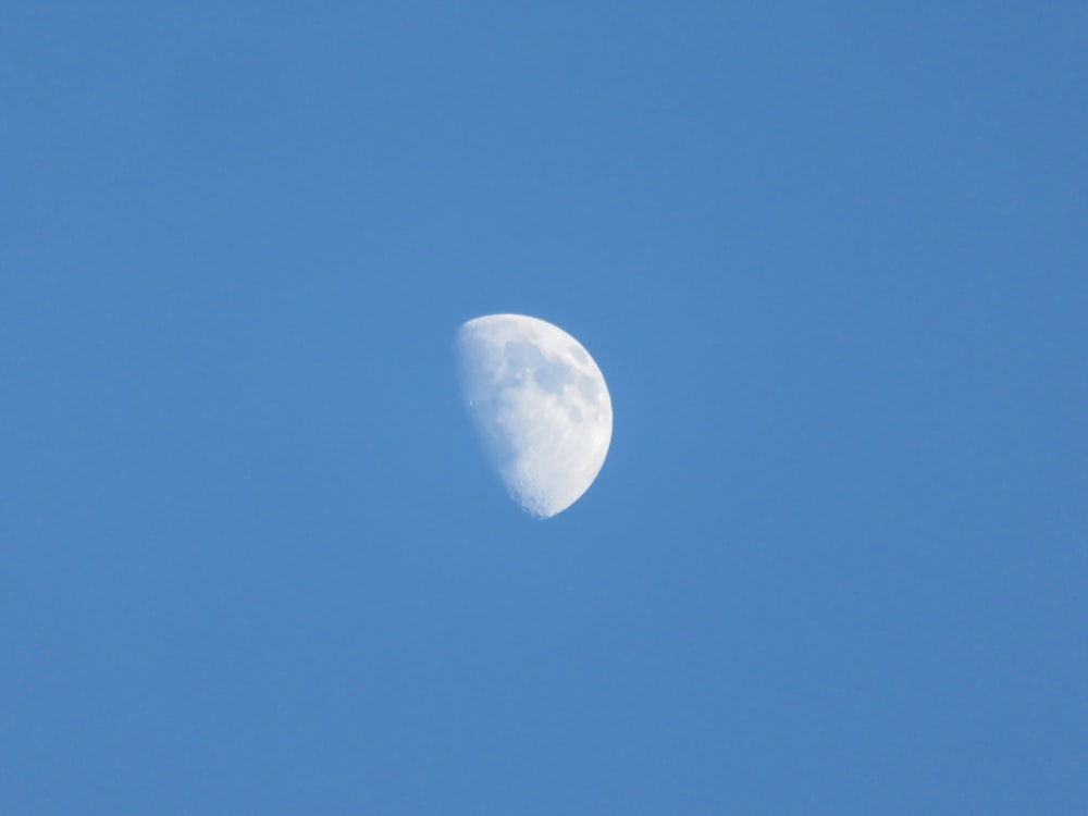 a half moon in a clear blue sky