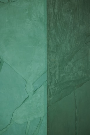 Close-up of freshly painted exterior walls in a soft green shade, showcasing smooth finish.