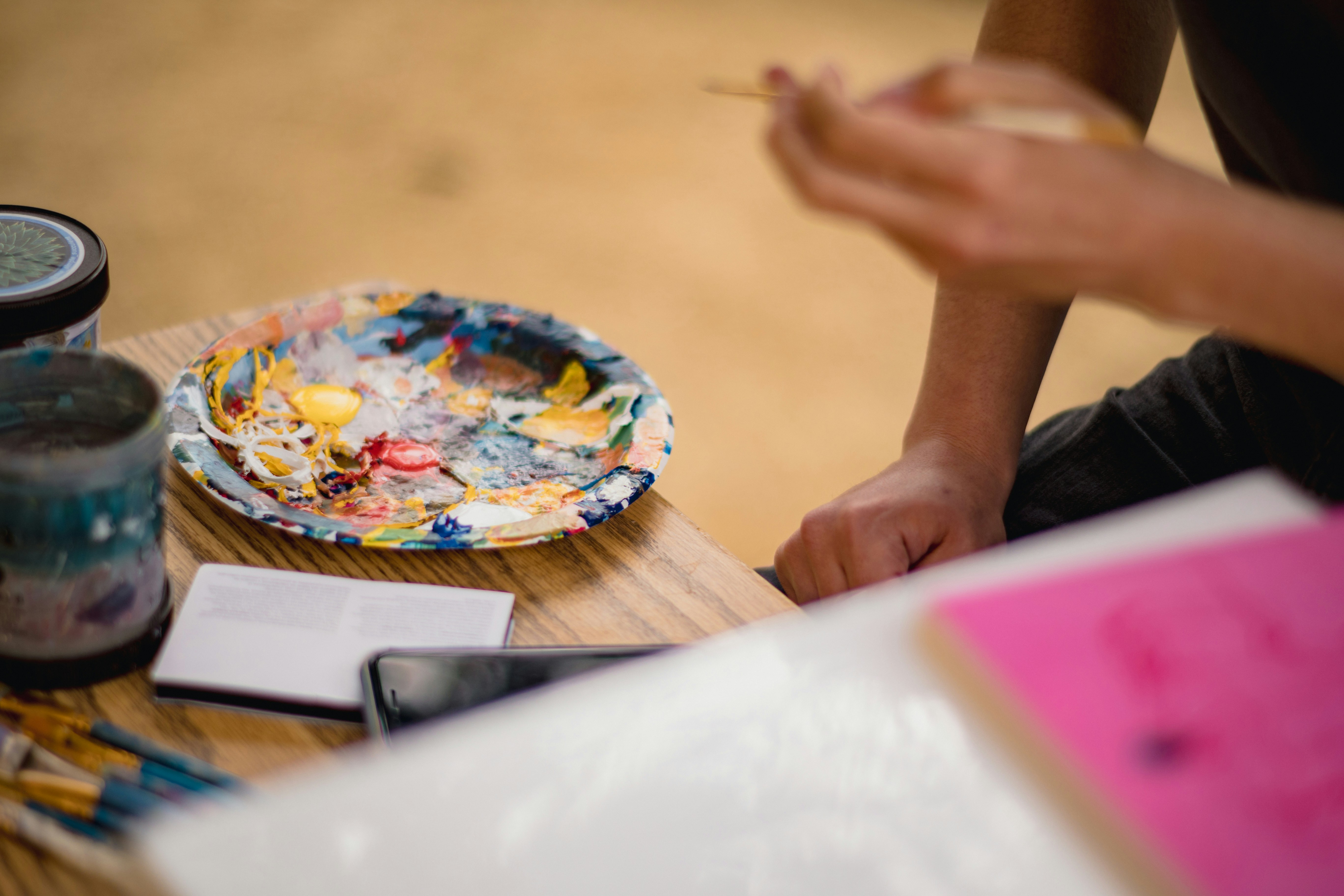 a person sitting at a table with a plate of paint