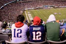 A passionate football fan wearing a vintage-style jersey, cheering in a stadium.