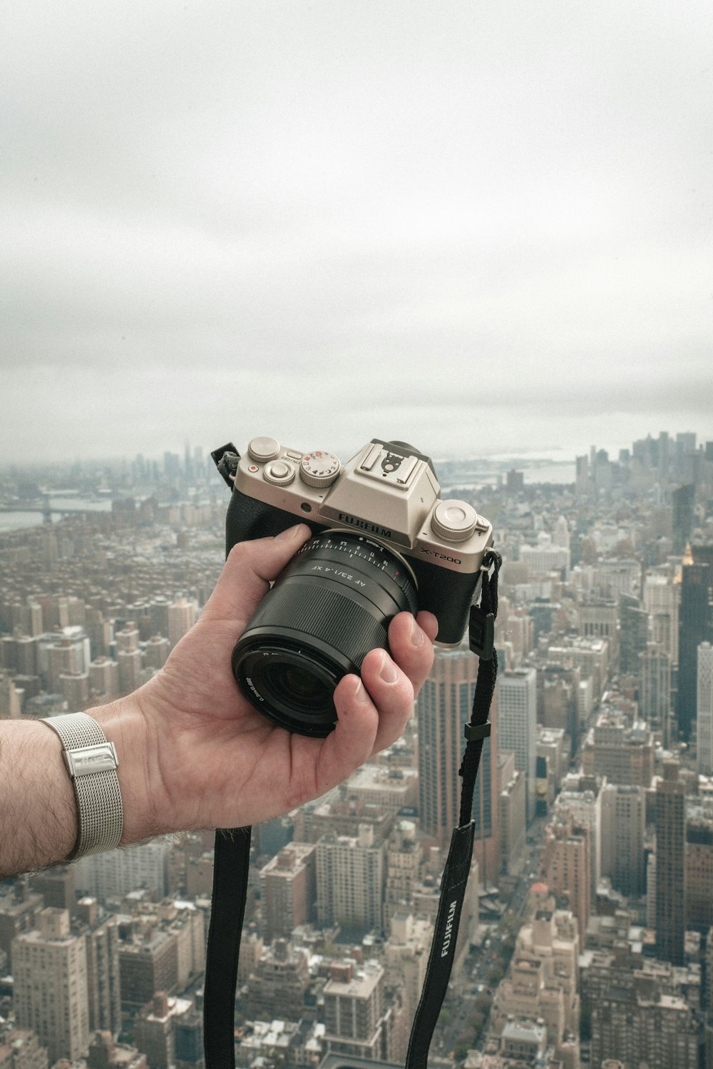 a person holding a camera over a city