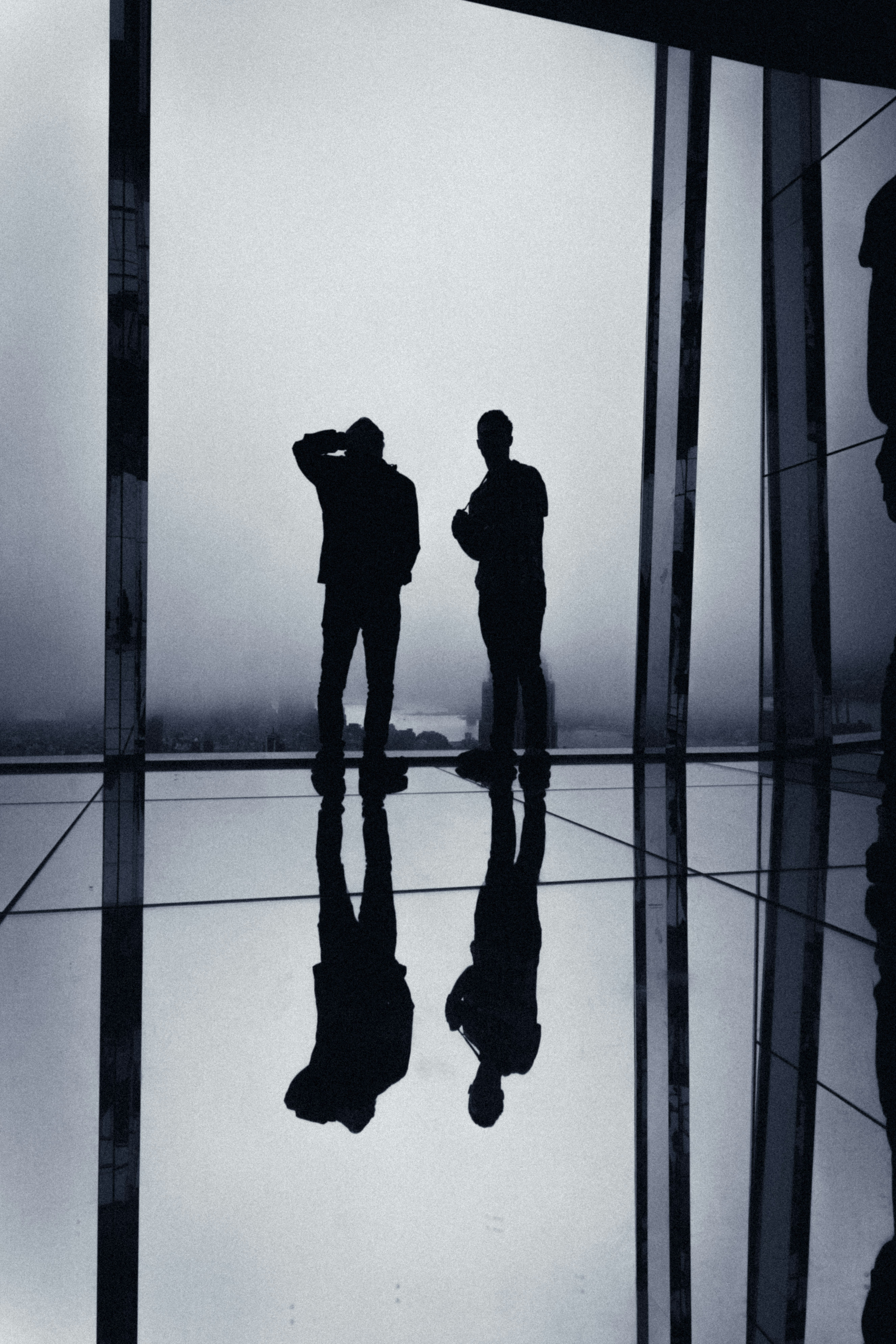 un couple de personnes debout devant un miroir