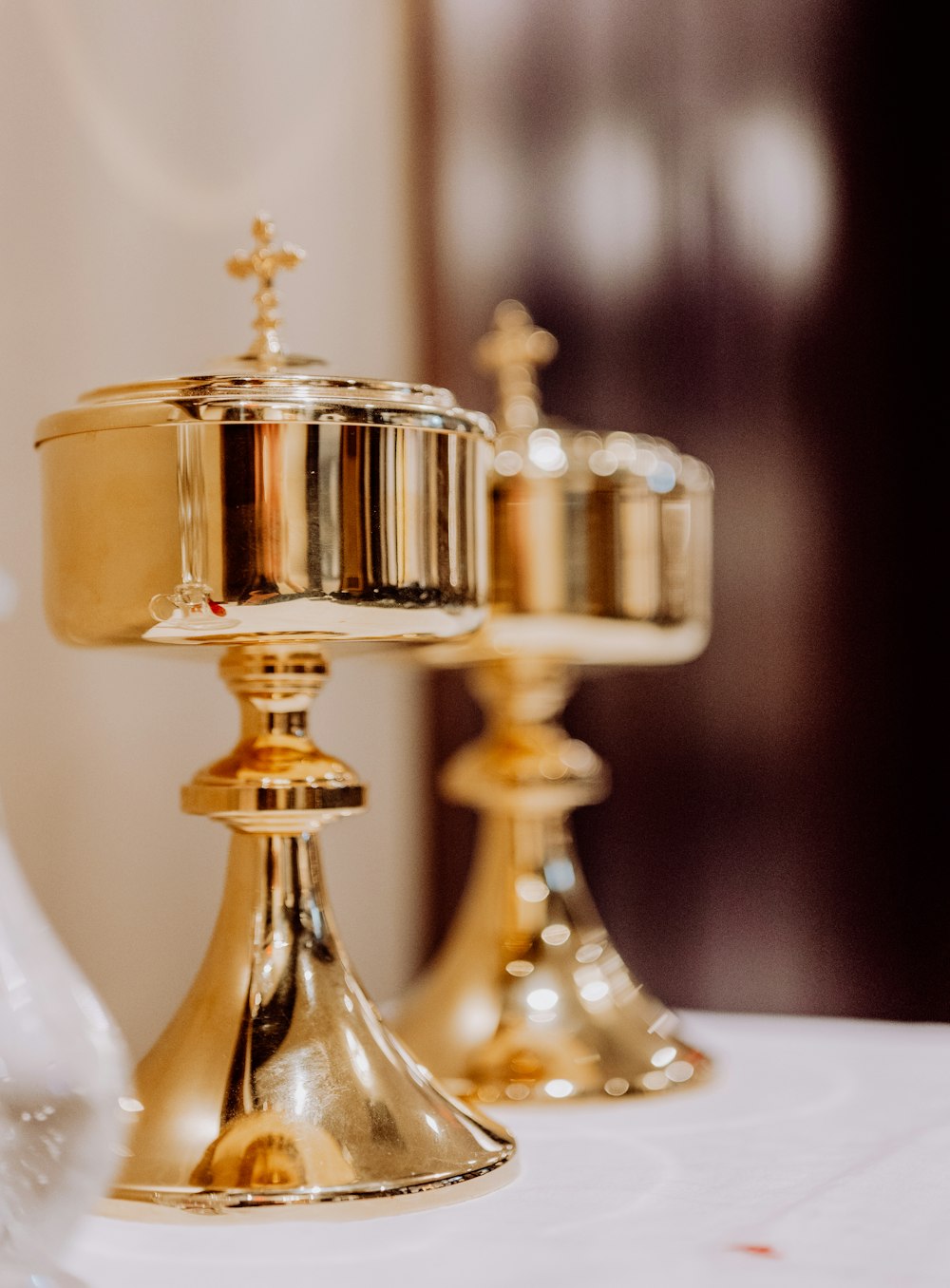 two golden candlesticks on a white table